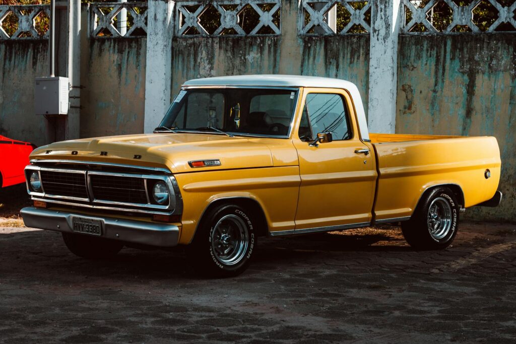 Yellow Ford Vintage Car Parked near the Ugly Concrete Wall