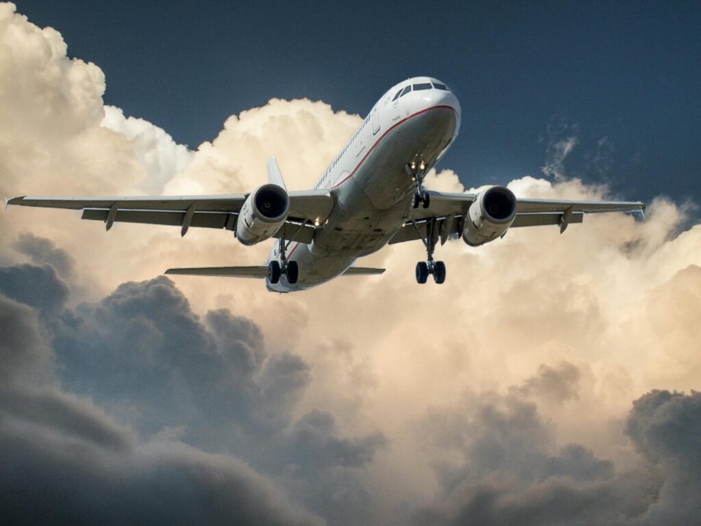 White and Red Plane Beside Clouds Low-angle Photography