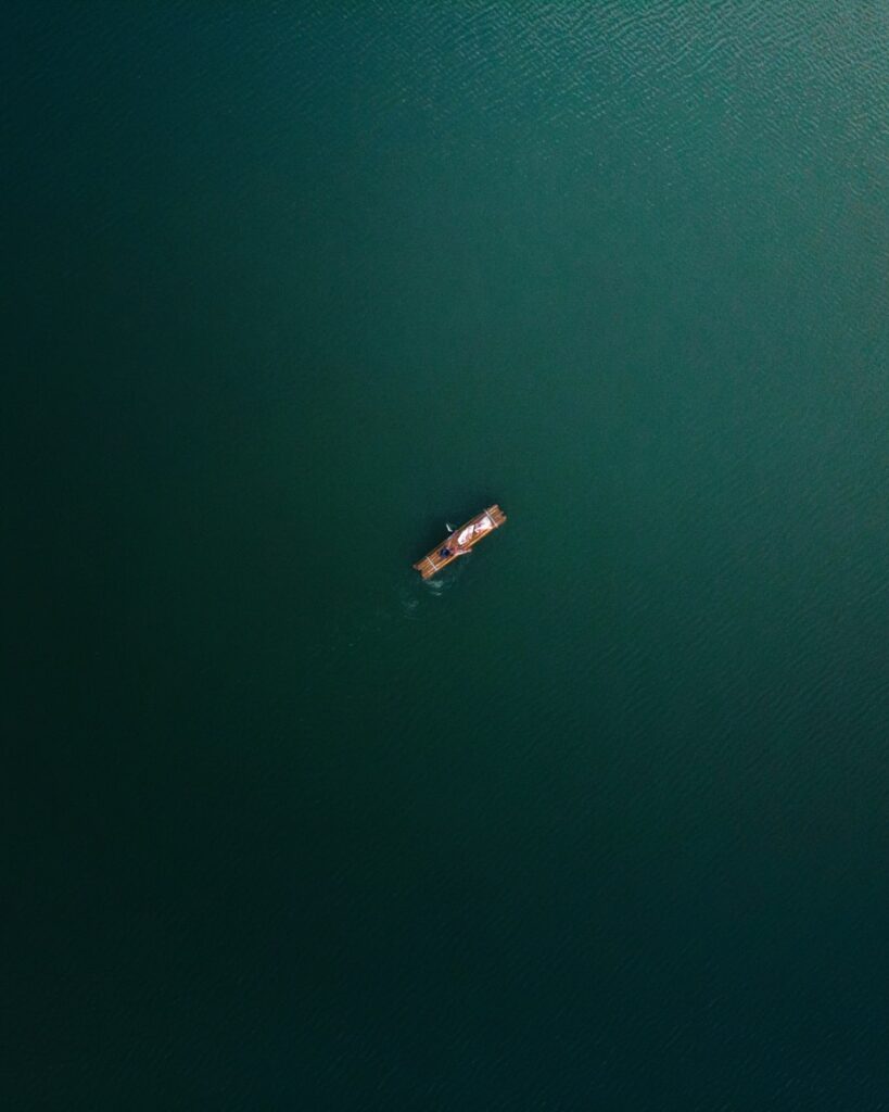 a small boat floating on top of a large body of water